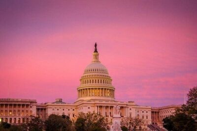 The Capitol dome under a pink sunset sky